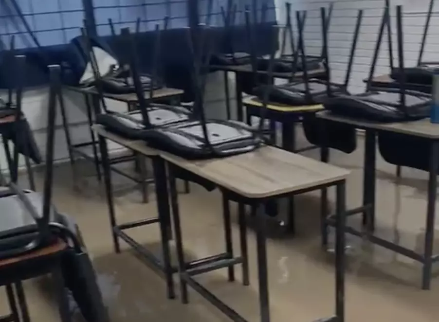 Las imágenes muestran a estudiantes saliendo con dificultad de sus salones de clases, los cuales se encontraban completamente inundados.